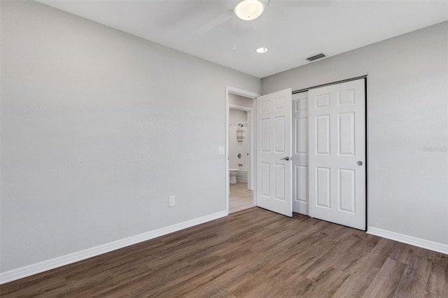 unfurnished bedroom with ceiling fan, a closet, and hardwood / wood-style flooring