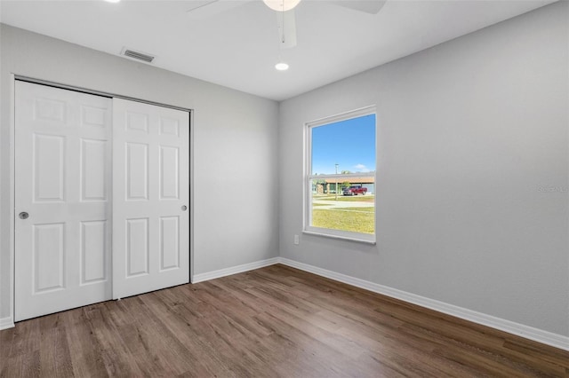 unfurnished bedroom featuring wood-type flooring, a closet, and ceiling fan