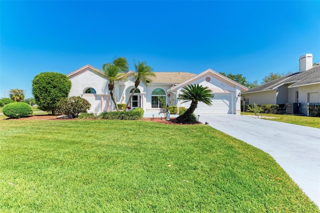 view of front of home featuring cooling unit, a garage, and a front yard