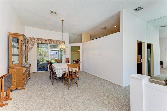 dining space with carpet floors, a textured ceiling, and a chandelier