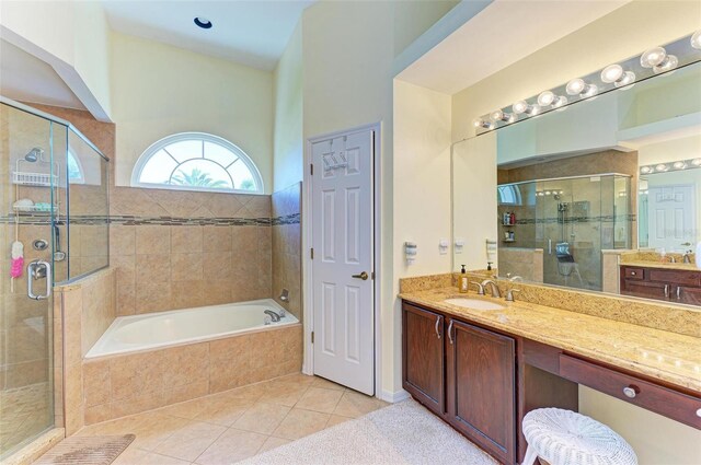 bathroom with tile patterned floors, vanity, and shower with separate bathtub