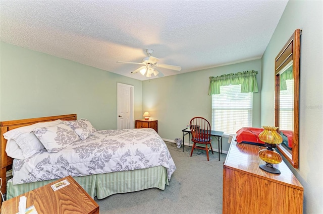 bedroom featuring a textured ceiling, light colored carpet, and ceiling fan