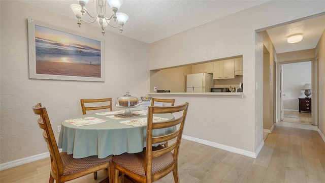 3609 59th Ave W Unit 4045, Bradenton, FL 34210 - dining room with light wood-style flooring, a chandelier, baseboards, and a textured ceiling