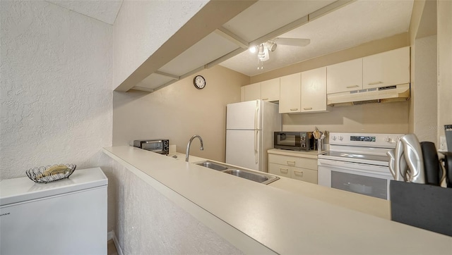 kitchen featuring white appliances, white cabinets, sink, ceiling fan, and kitchen peninsula