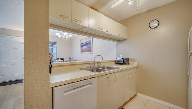 kitchen featuring sink, light hardwood / wood-style flooring, white dishwasher, a textured ceiling, and ceiling fan with notable chandelier