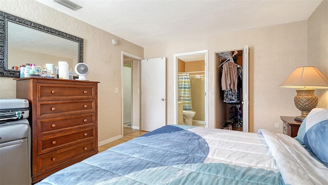 3609 59th Ave W Unit 4045, Bradenton, FL 34210 - bedroom with a textured wall, light wood-style floors, a walk in closet, ensuite bath, and a closet