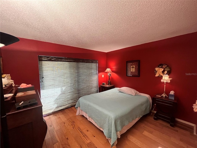 bedroom featuring a textured ceiling and hardwood / wood-style flooring