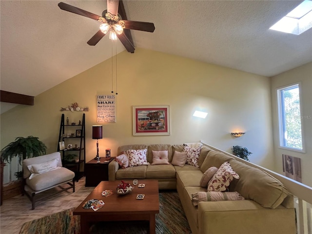 living room featuring carpet flooring, lofted ceiling with skylight, ceiling fan, and a textured ceiling