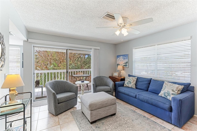 tiled living room with a textured ceiling and ceiling fan