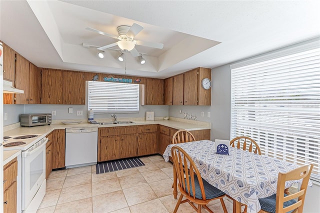 kitchen with ceiling fan, a raised ceiling, white appliances, and sink