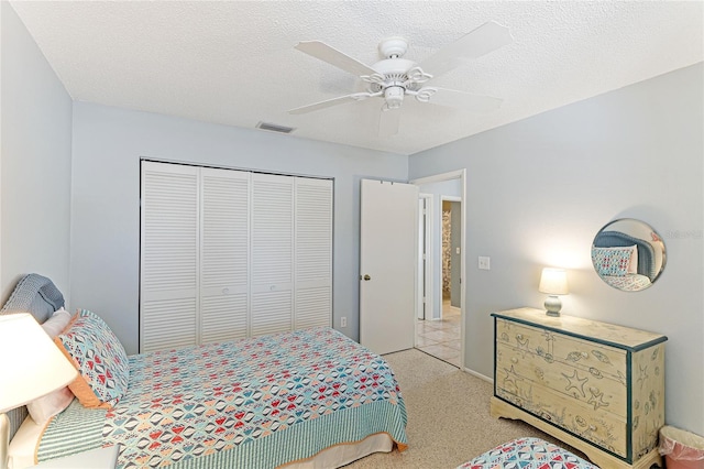 bedroom featuring ceiling fan, a closet, and a textured ceiling