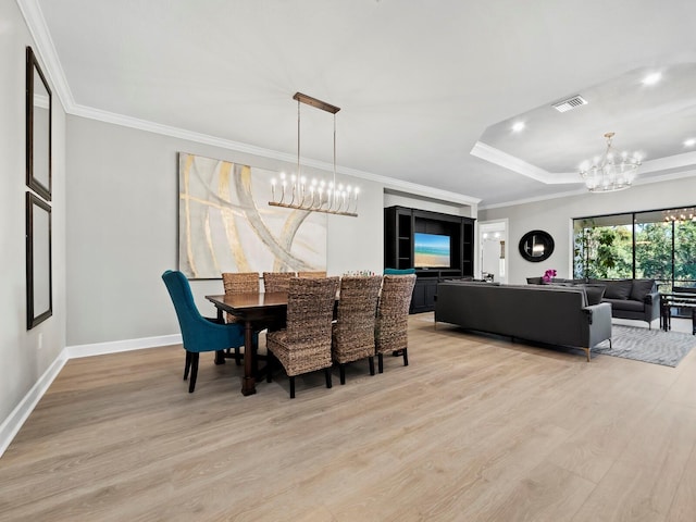 dining area featuring crown molding, a chandelier, and light wood-type flooring