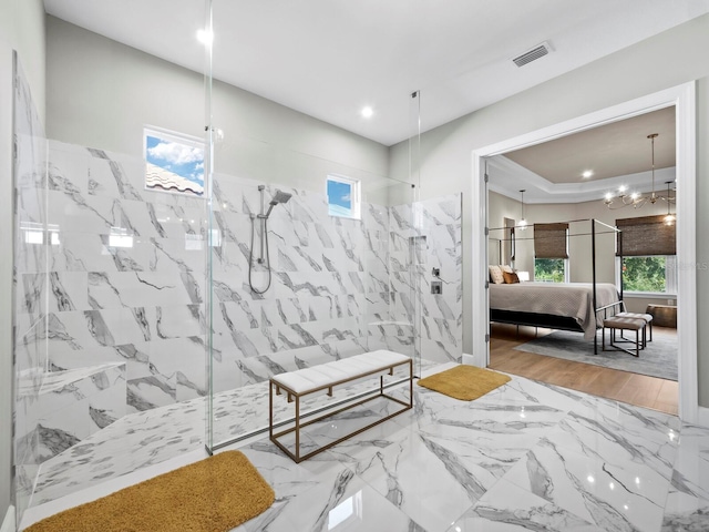 bathroom featuring a tile shower, tile walls, a healthy amount of sunlight, and wood-type flooring