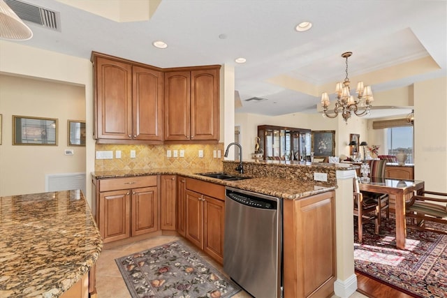 kitchen featuring dishwasher, sink, tasteful backsplash, a notable chandelier, and kitchen peninsula