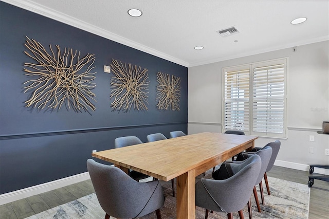 dining room with hardwood / wood-style floors and crown molding