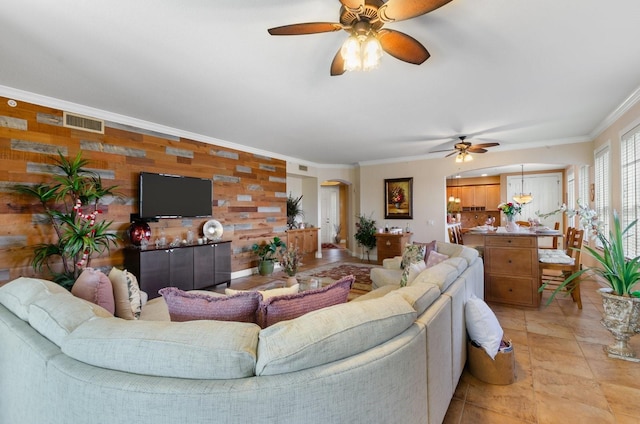 living room featuring ceiling fan, crown molding, and wood walls