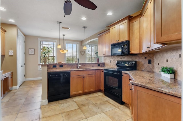 kitchen with black appliances, sink, decorative light fixtures, light stone counters, and kitchen peninsula