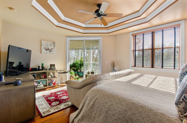 bedroom featuring access to outside, multiple windows, ceiling fan, and wood-type flooring