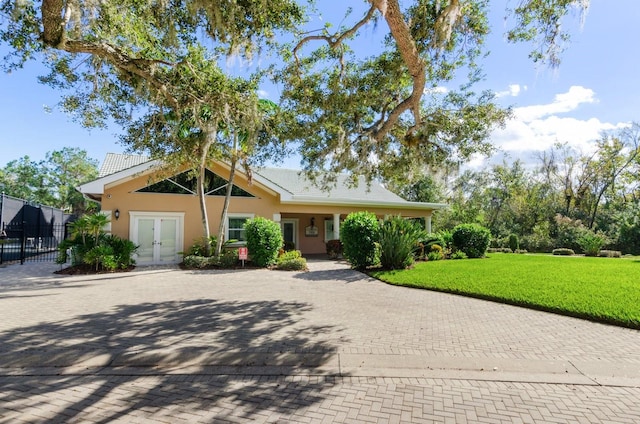 ranch-style house with french doors and a front lawn