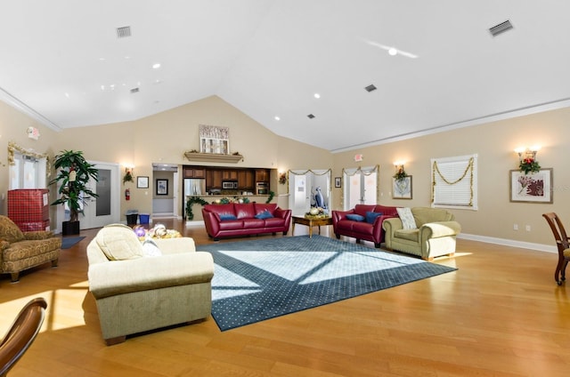 living room featuring ornamental molding, high vaulted ceiling, and light hardwood / wood-style flooring