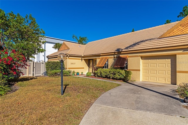 single story home featuring a front lawn and a garage