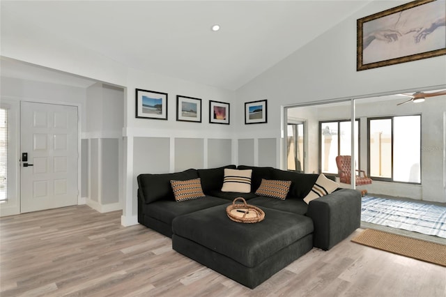 living room with ceiling fan, high vaulted ceiling, and light hardwood / wood-style flooring