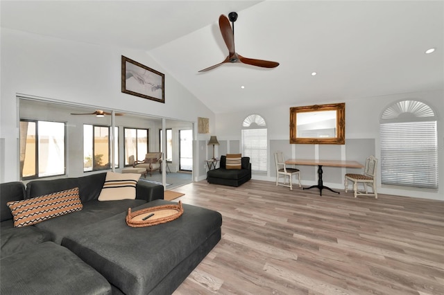 living room featuring ceiling fan, light hardwood / wood-style flooring, and lofted ceiling