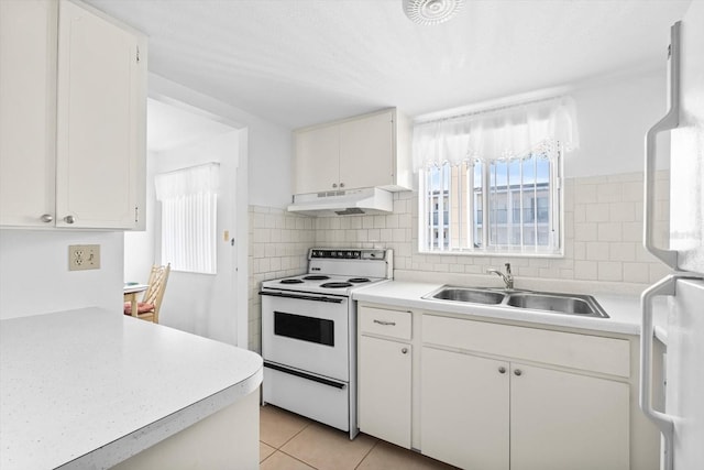 kitchen with white cabinets, sink, light tile patterned flooring, and electric stove