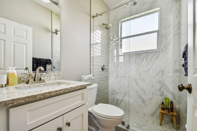 bathroom with vanity, toilet, and a shower with door