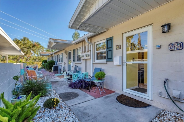 doorway to property with central air condition unit and a patio