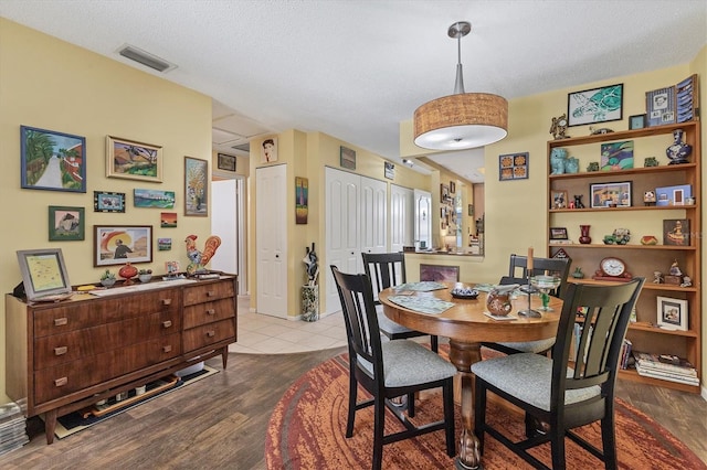 dining room featuring a textured ceiling and light wood-type flooring