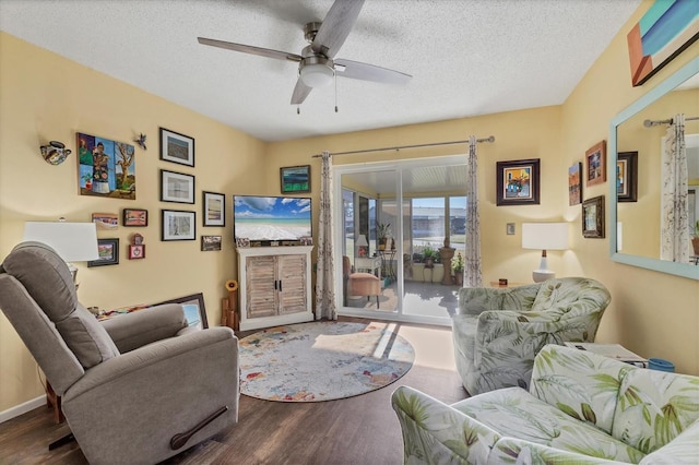 living room featuring hardwood / wood-style floors, ceiling fan, and a textured ceiling