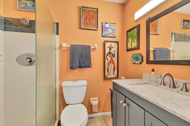 bathroom featuring tile patterned floors, vanity, tiled shower, and toilet