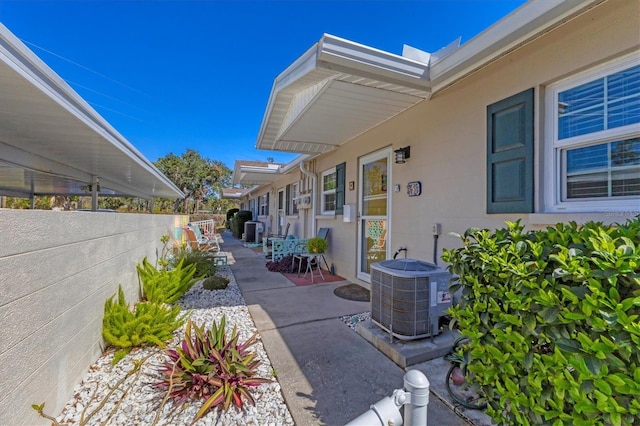 view of patio featuring central AC unit and fence