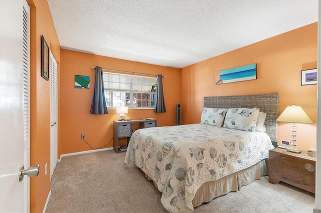 bedroom featuring baseboards, a textured ceiling, and light colored carpet