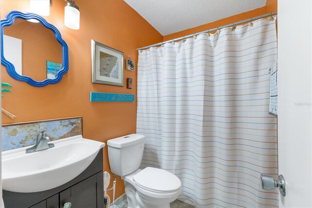 full bathroom featuring toilet, a textured ceiling, and vanity