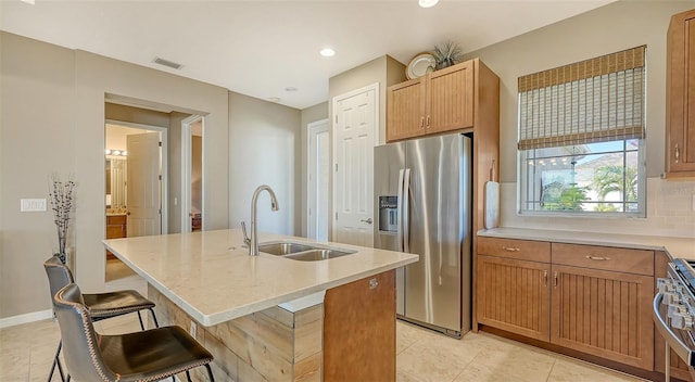 7525 Alumni Trl, Sarasota, FL 34243 - kitchen with appliances with stainless steel finishes, backsplash, a center island with sink, a kitchen bar, and recessed lighting