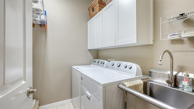 laundry room featuring light tile patterned floors, sink, washing machine and clothes dryer, and cabinets