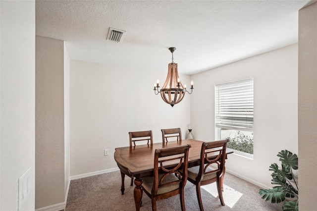 carpeted dining area featuring a textured ceiling and a notable chandelier