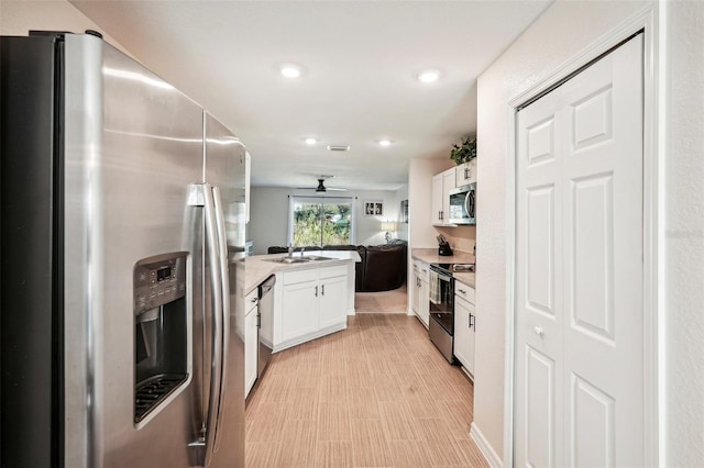 kitchen featuring ceiling fan, sink, white cabinets, and appliances with stainless steel finishes