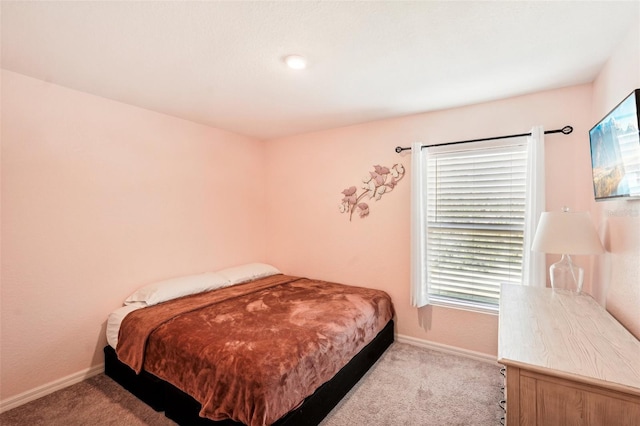 bedroom with light colored carpet and multiple windows