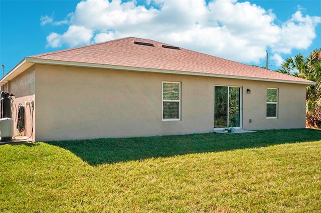 rear view of house featuring a yard