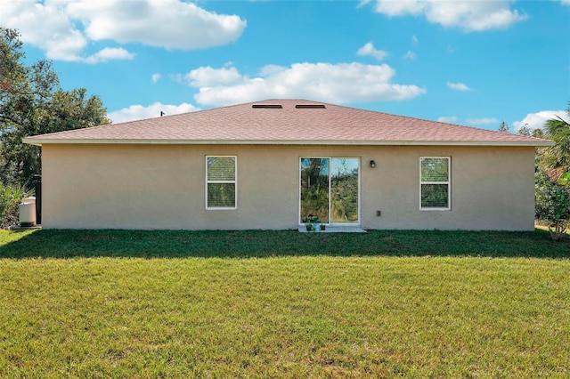 rear view of property with a lawn