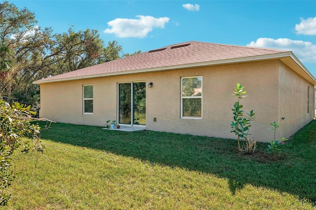 rear view of house featuring a yard