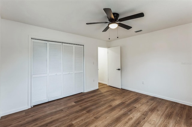 unfurnished bedroom featuring ceiling fan, dark wood-type flooring, and a closet