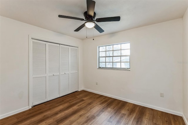 unfurnished bedroom with a closet, dark hardwood / wood-style floors, and ceiling fan