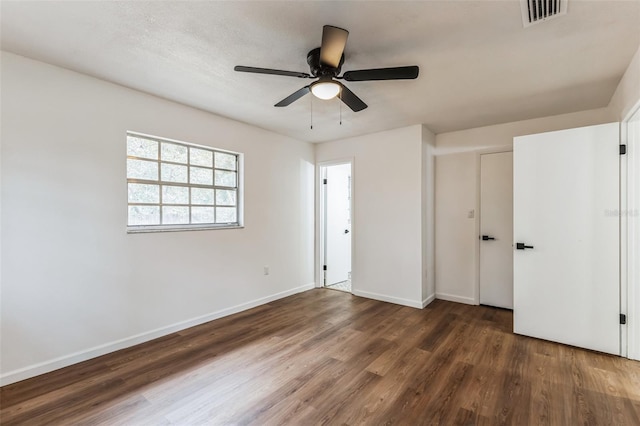 unfurnished bedroom featuring ceiling fan and dark wood-type flooring