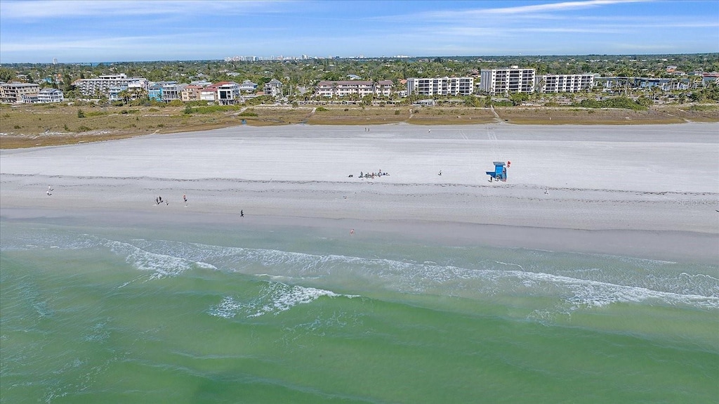 drone / aerial view with a beach view and a water view