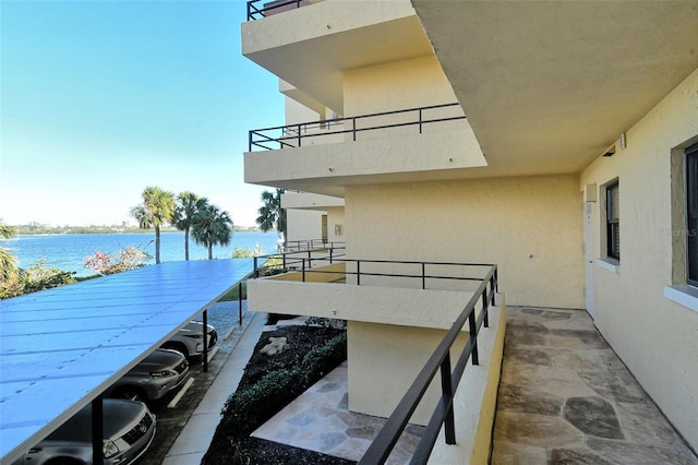 dock area with a water view and a balcony