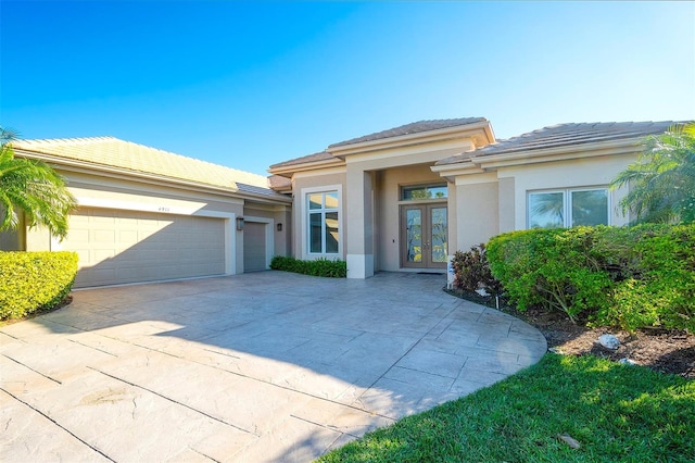 prairie-style house featuring french doors and a garage